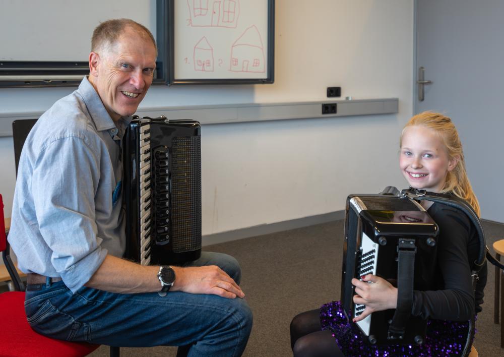 Meisje krijgt muziekles op een accordeon.