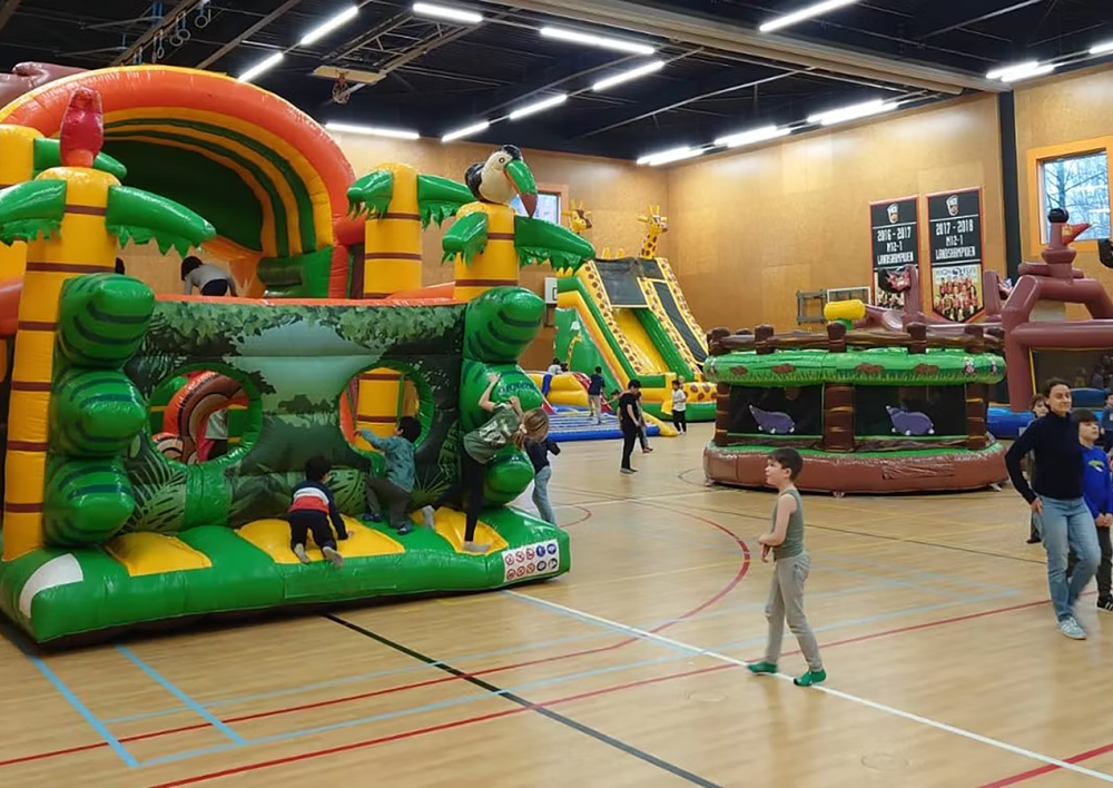 Kinderen bij een springkussen in een gymhal