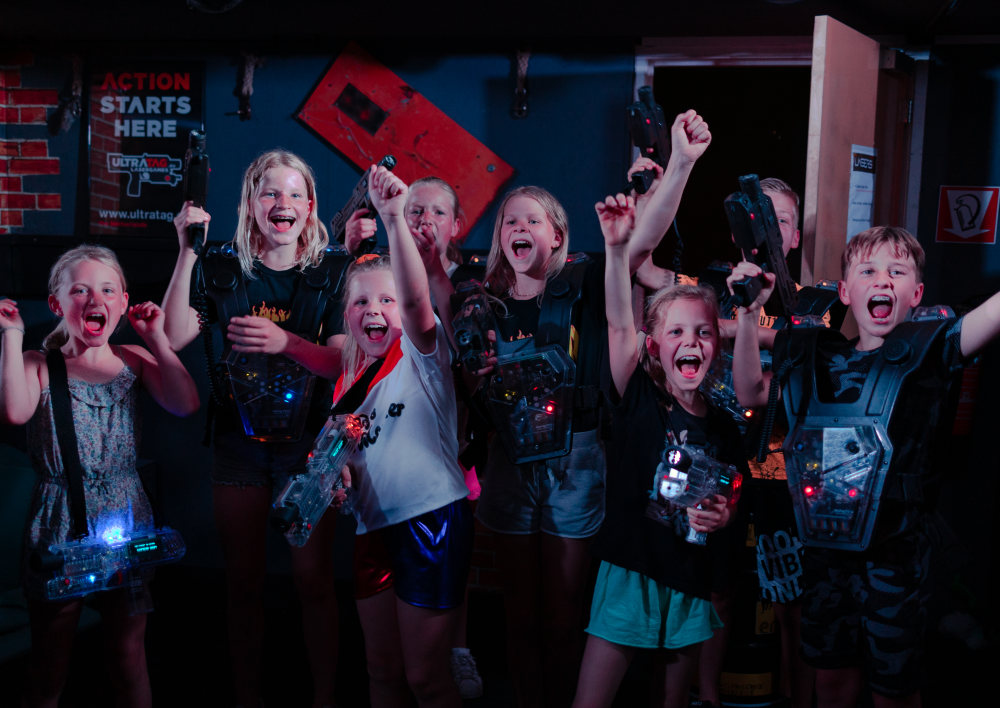 Een groep kinderen juicht na het lasergamen
