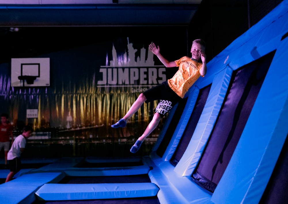 Jongen springt op een trampoline in het donker